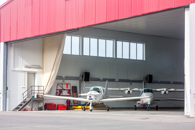 Vue int&eacute;rieure d'un hangar d'avion en acier sans colonnes montrant la disposition de la ventilation et de l'&eacute;clairage industriels